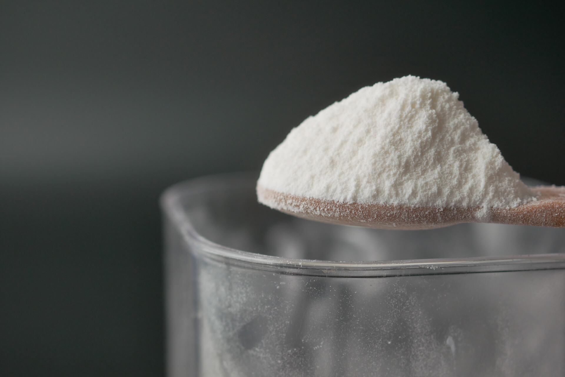 Close-up van wit poeder (baking soda) op een lepel, als huismiddel tegen kalknagels